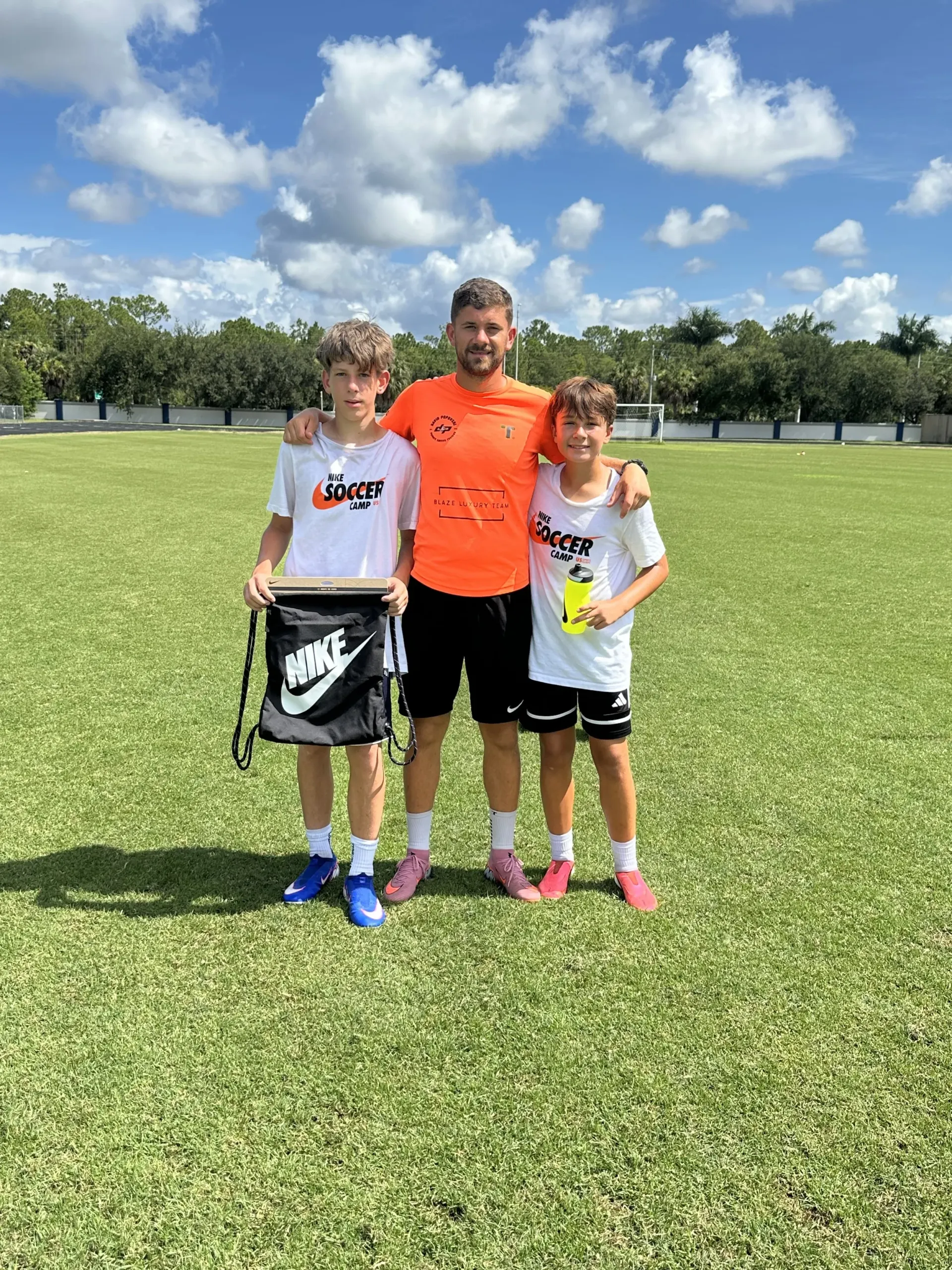 Coach David with two campers and a Nike bag