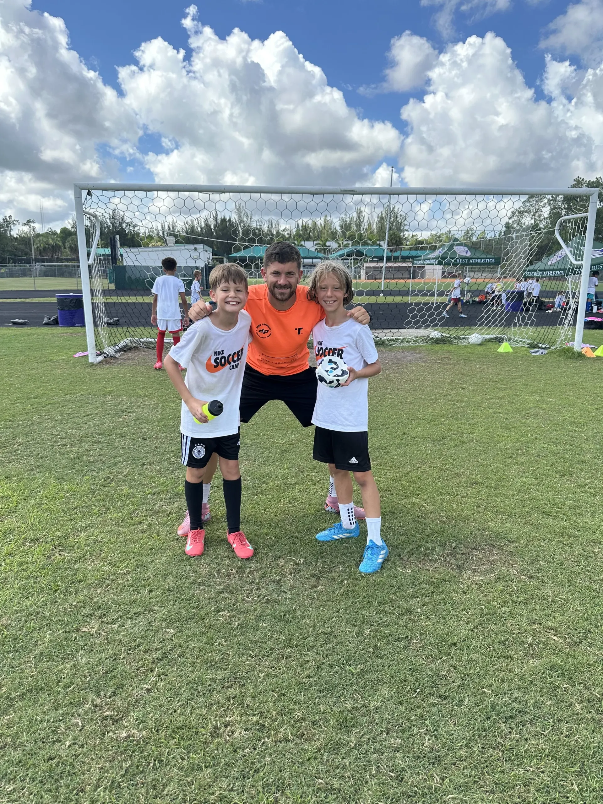 Coach David with two campers in front of the goal